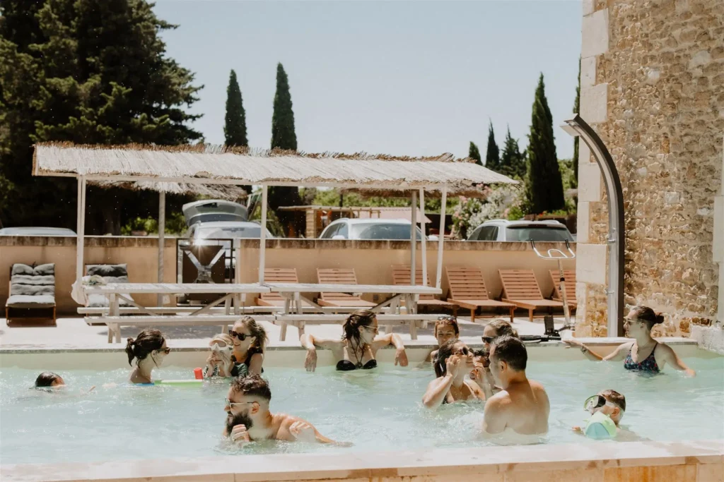 Groupe d'amis dans la piscine extérieure du Mas Loisonville